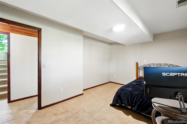 bedroom featuring carpet floors, a textured ceiling, baseboards, and visible vents