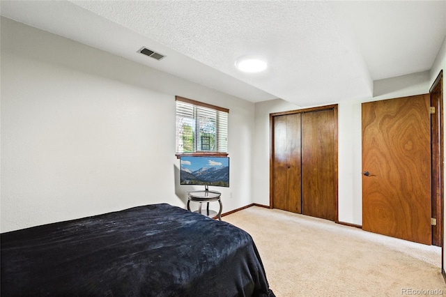 carpeted bedroom featuring baseboards, visible vents, and a closet