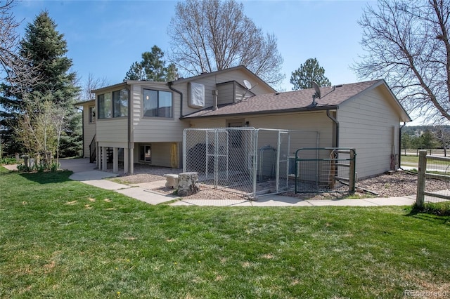 rear view of house featuring fence, a gate, and a yard
