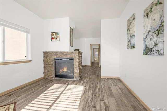 12255 Forest Green Dr, Elbert, CO 80106 - unfurnished living room featuring a stone fireplace, wood finished floors, and baseboards