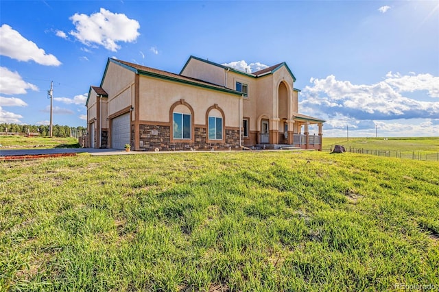 12255 Forest Green Dr, Elbert, CO 80106 - view of front of home with stucco siding, a front lawn, an attached garage, driveway, and stone siding