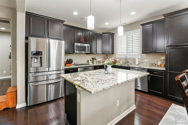 3014 E 143rd Dr, Thornton, CO 80602 - kitchen with appliances with stainless steel finishes, dark wood finished floors, light stone countertops, a center island, and hanging light fixtures