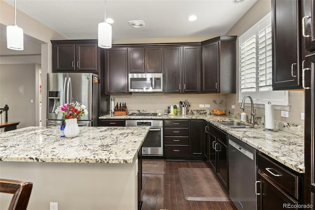3014 E 143rd Dr, Thornton, CO 80602 - kitchen with stainless steel appliances, dark wood-style floors, dark brown cabinets, light stone countertops, and recessed lighting