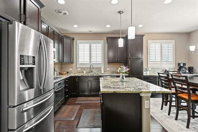 3014 E 143rd Dr, Thornton, CO 80602 - kitchen with stainless steel fridge, healthy amount of natural light, recessed lighting, dark brown cabinetry, and light stone counters