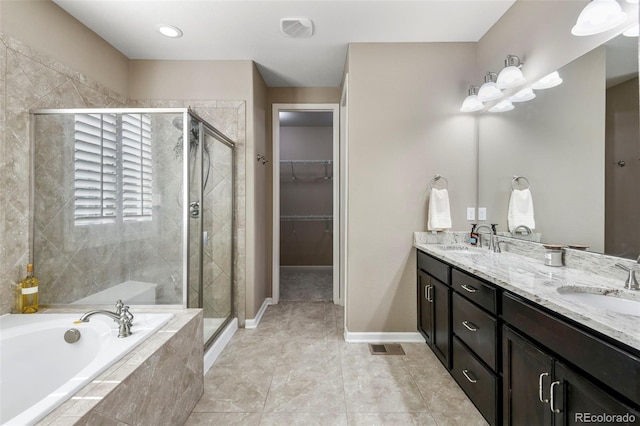 3014 E 143rd Dr, Thornton, CO 80602 - bathroom featuring a garden tub, double vanity, a shower stall, and a spacious closet