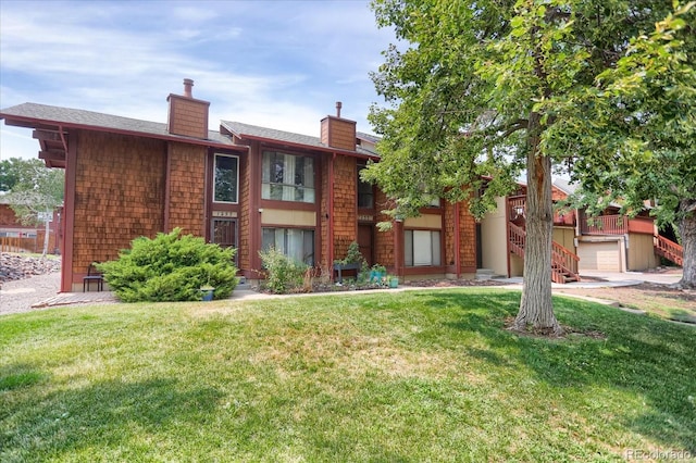 view of front facade featuring stairway, a front yard, and a chimney