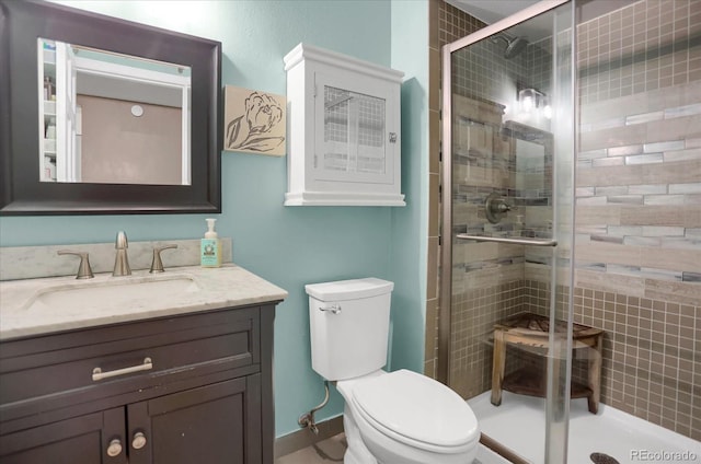 bathroom with a stall shower, vanity, and toilet