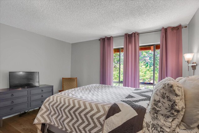 bedroom featuring a textured ceiling and dark wood-type flooring