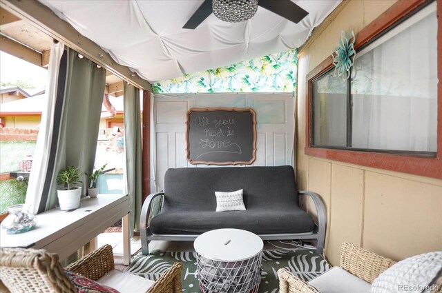 living area featuring a sunroom and a ceiling fan