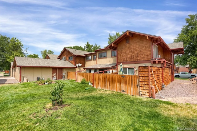 rear view of house featuring a yard and fence