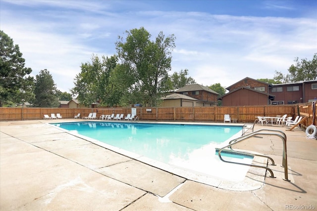 pool with a patio area and a fenced backyard