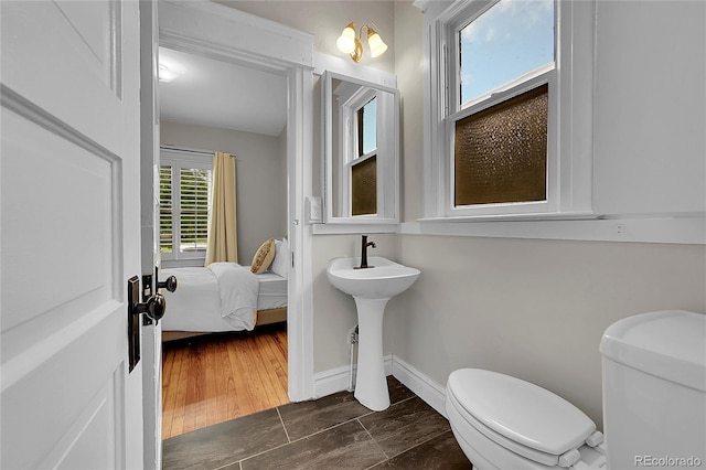 half bath featuring toilet and baseboards