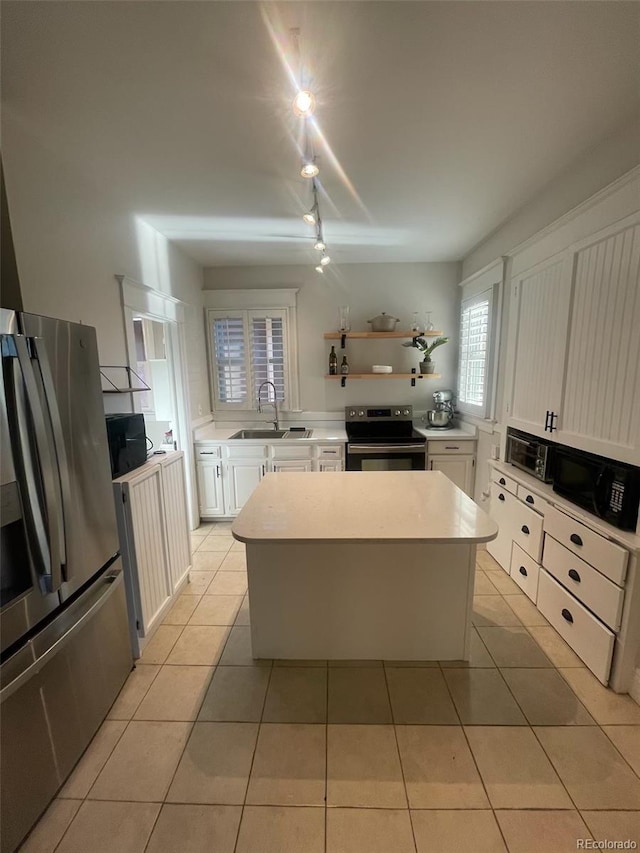 kitchen featuring white cabinetry, appliances with stainless steel finishes, a sink, and a center island