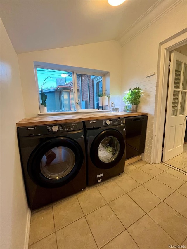 laundry area with light tile patterned floors, separate washer and dryer, ornamental molding, and laundry area
