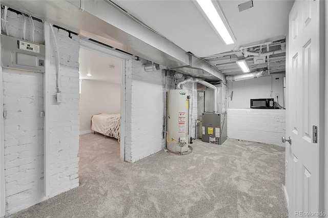 unfinished below grade area with heating unit, carpet, and water heater