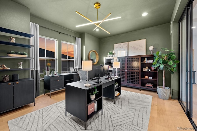 office area with a chandelier and light wood-style floors