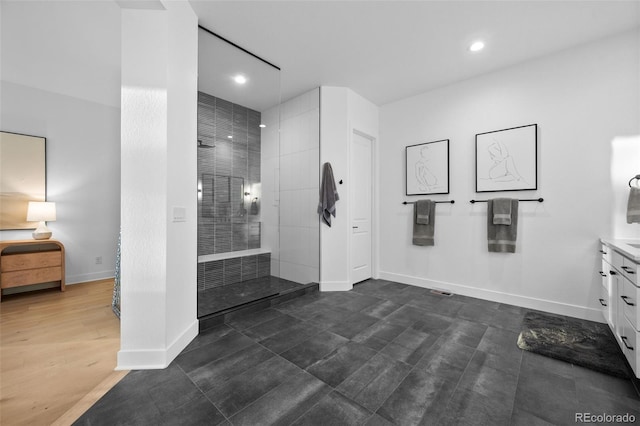 full bath featuring vanity, recessed lighting, baseboards, and walk in shower