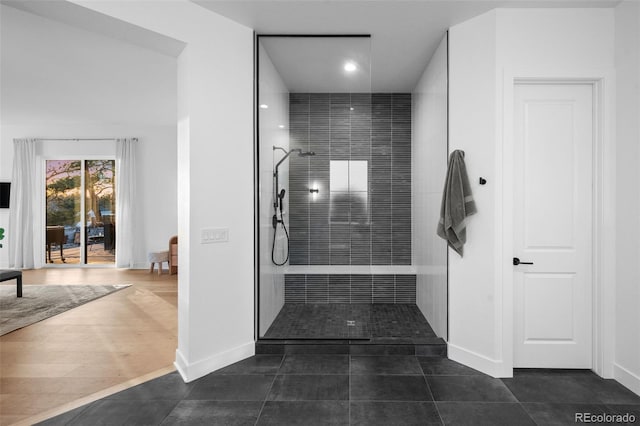 full bath with tile patterned floors, baseboards, and walk in shower