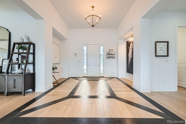 foyer featuring baseboards, an inviting chandelier, and wood-type flooring