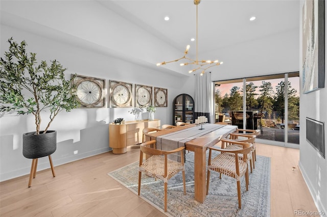 dining space with light wood finished floors, baseboards, a notable chandelier, and recessed lighting