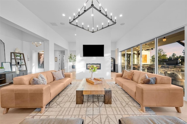 living area featuring visible vents, light wood-style flooring, recessed lighting, and a chandelier