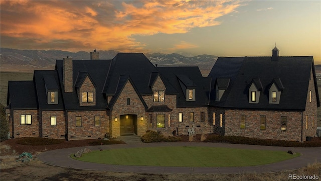 view of front facade featuring a mountain view and a yard