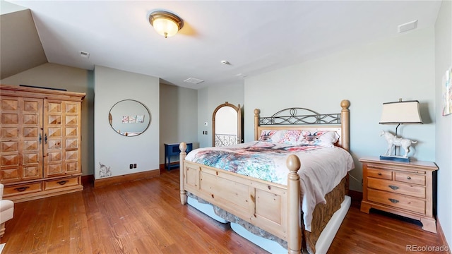 bedroom featuring vaulted ceiling and hardwood / wood-style flooring