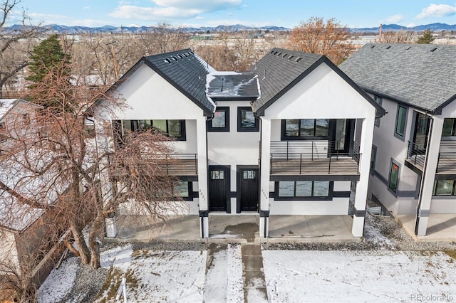 view of front of house with a balcony and a mountain view