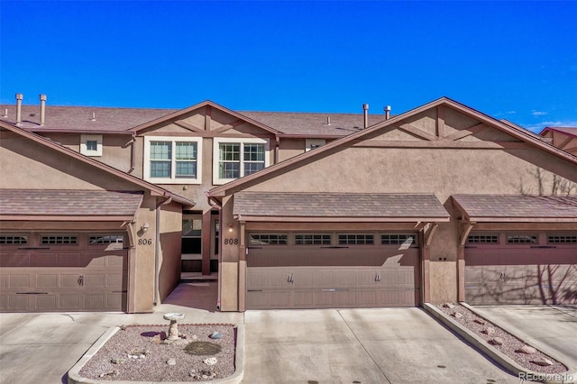 view of property with stucco siding, concrete driveway, and a garage