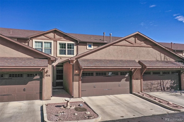 view of front of home with a garage, driveway, and stucco siding