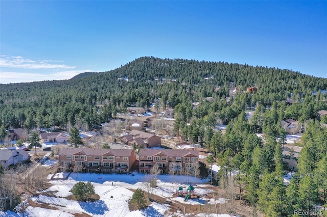 drone / aerial view featuring a mountain view, a wooded view, and a residential view