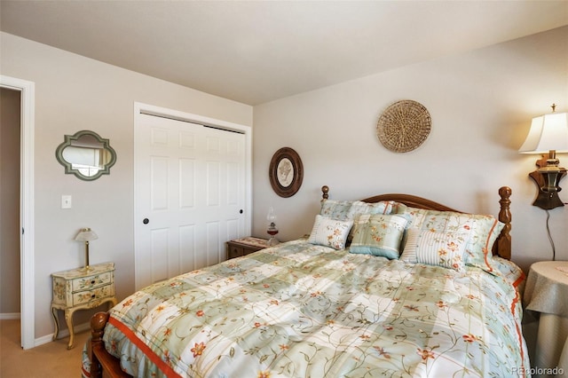 carpeted bedroom with a closet and baseboards