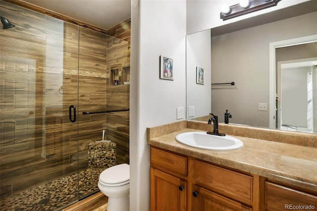 bathroom with vanity, toilet, and a shower stall