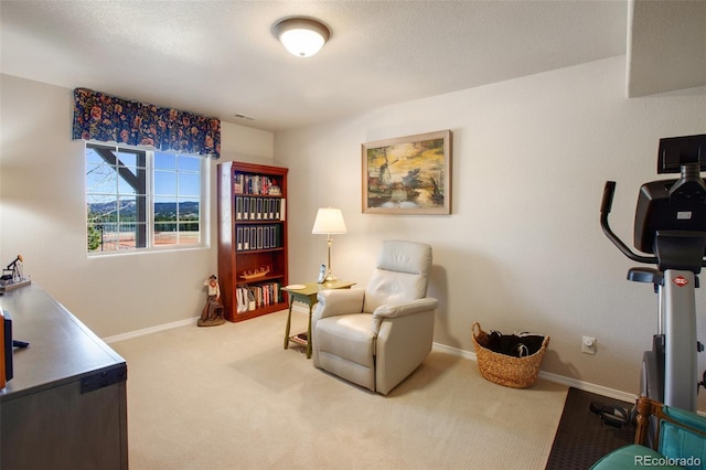 sitting room with visible vents, baseboards, carpet floors, and a textured ceiling