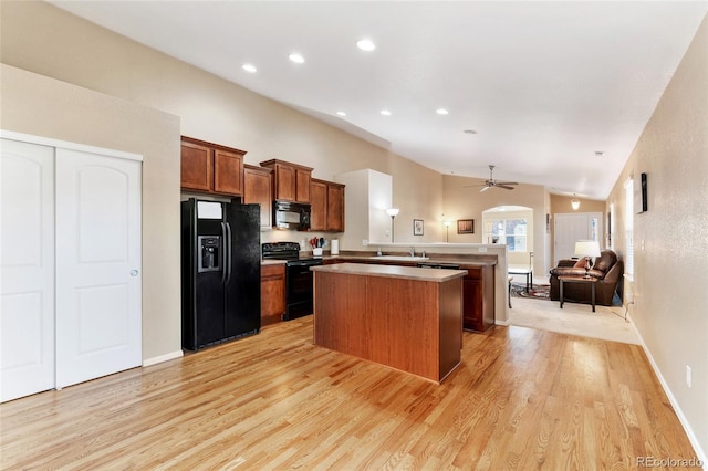 kitchen with black appliances, light hardwood / wood-style floors, sink, kitchen peninsula, and ceiling fan