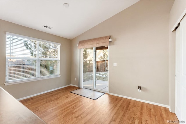 doorway featuring light hardwood / wood-style flooring and vaulted ceiling