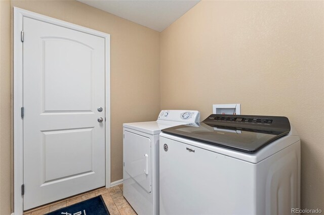 washroom featuring light tile patterned floors and washing machine and clothes dryer