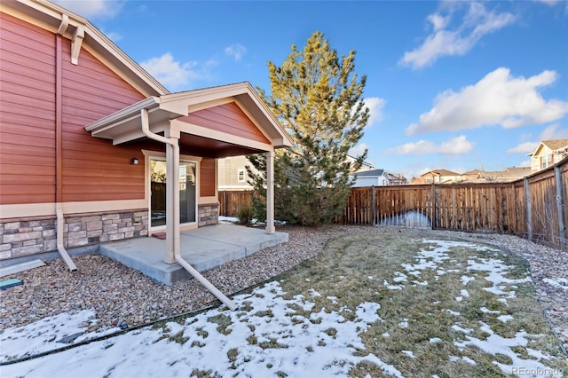 snowy yard featuring a patio area