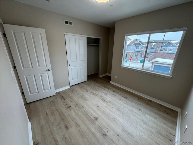 unfurnished bedroom featuring light hardwood / wood-style floors and a closet