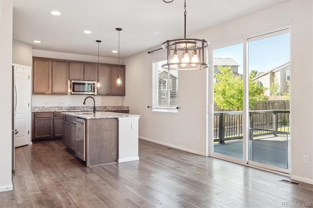 1457 Castle Creek Cir, Castle Rock, CO 80104 - kitchen featuring appliances with stainless steel finishes, backsplash, a center island with sink, recessed lighting, and dark wood-style floors