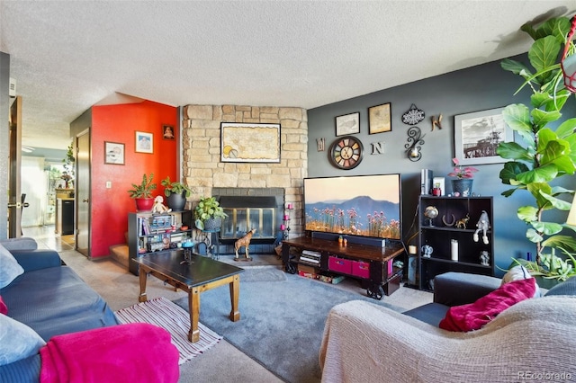 carpeted living area with a textured ceiling and a stone fireplace