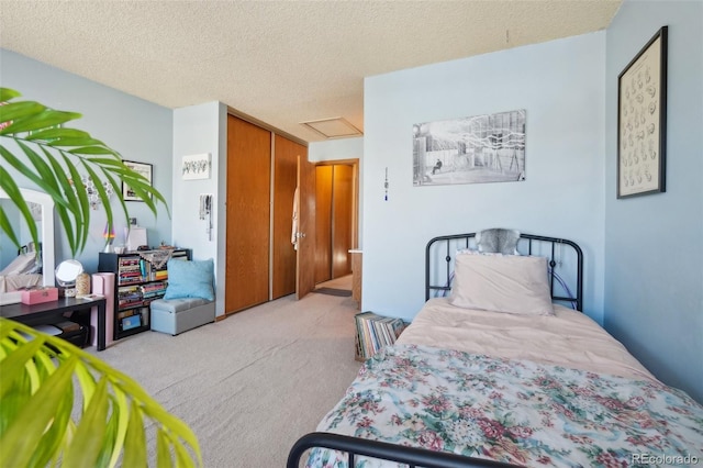carpeted bedroom with attic access and a textured ceiling