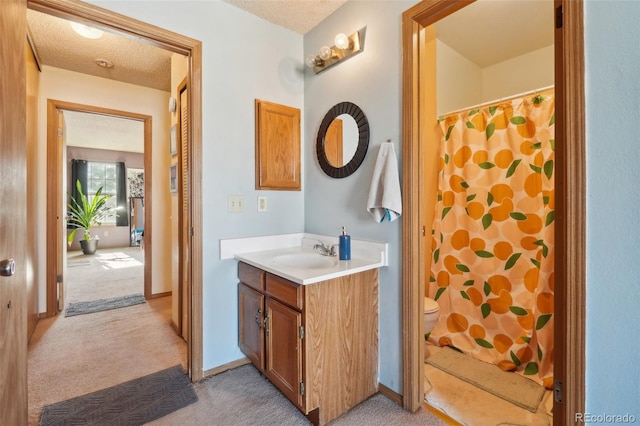 full bathroom featuring toilet, vanity, a shower with shower curtain, and a textured ceiling