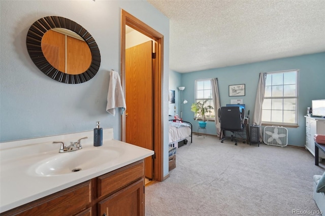 ensuite bathroom featuring a textured ceiling and vanity