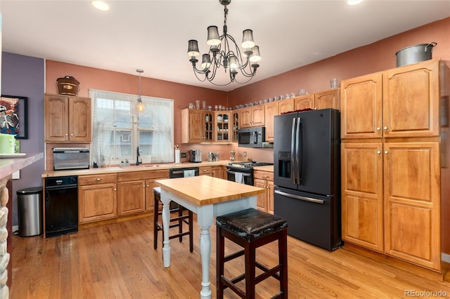 200 Rose St, Georgetown, CO 80444 - kitchen with black appliances, a chandelier, light wood-type flooring, decorative light fixtures, and glass insert cabinets