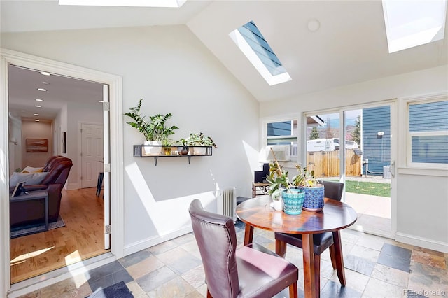 2221 Illinois St, Golden, CO 80401 - dining area featuring a skylight, high vaulted ceiling, light stone finish floors, and radiator heating unit