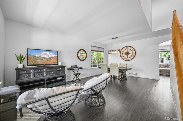 17395 E Dewberry Dr, Parker, CO 80134 - living room with arched walkways, wood finished floors, and baseboards