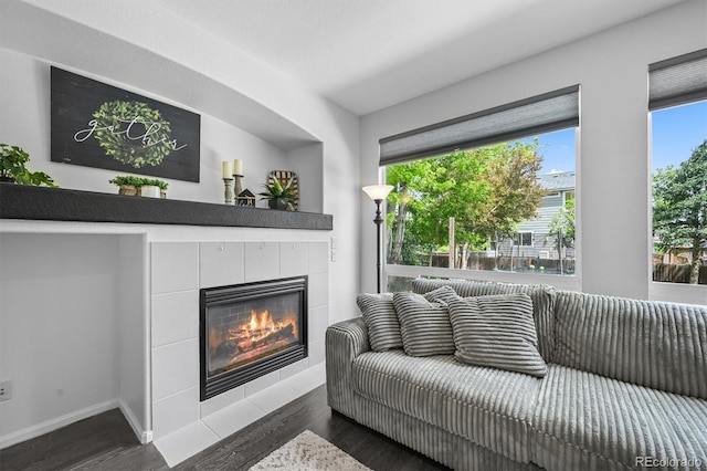 17395 E Dewberry Dr, Parker, CO 80134 - living area with a tile fireplace, dark wood-style flooring, and baseboards