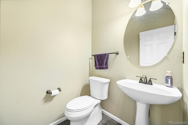 17395 E Dewberry Dr, Parker, CO 80134 - bathroom featuring toilet, baseboards, and wood finished floors
