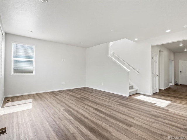 1023 Odessa Lake Rd, Severance, CO 80550 - unfurnished living room with wood finished floors, stairway, and recessed lighting